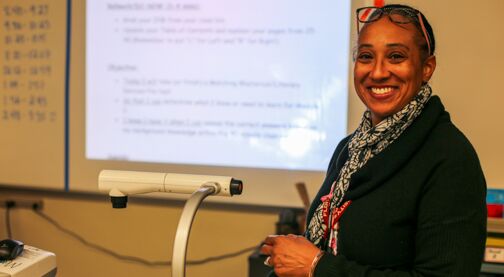 Support a teacher's classroom, teacher smiling in front of whiteboard, Hillsborough Education Foundation