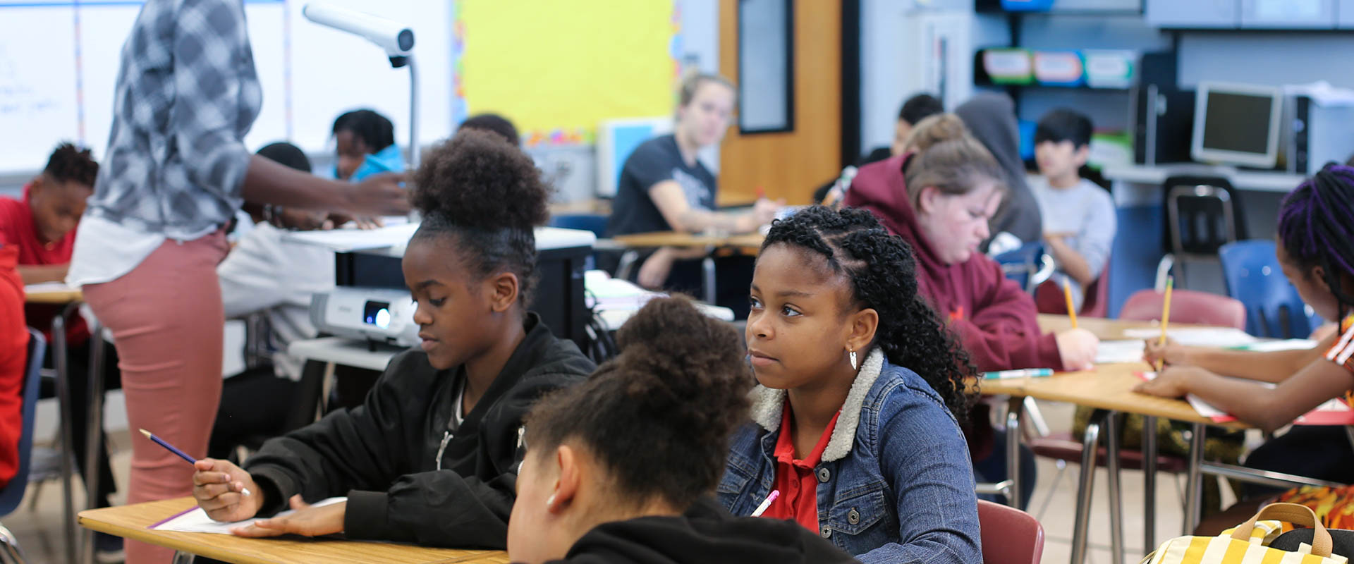 Jóvenes estudiantes en el aula de la escuela secundaria, escribiendo en papel en el escritorio, Hillsborough Education Foundation