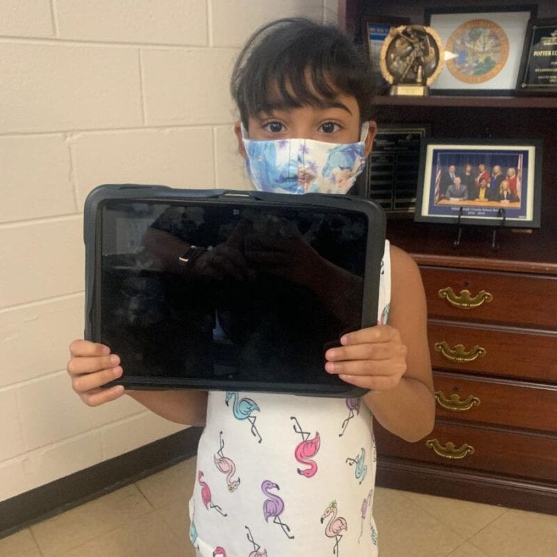 Student holding tablet provided by Hillsborough Education Foundation for summer learning